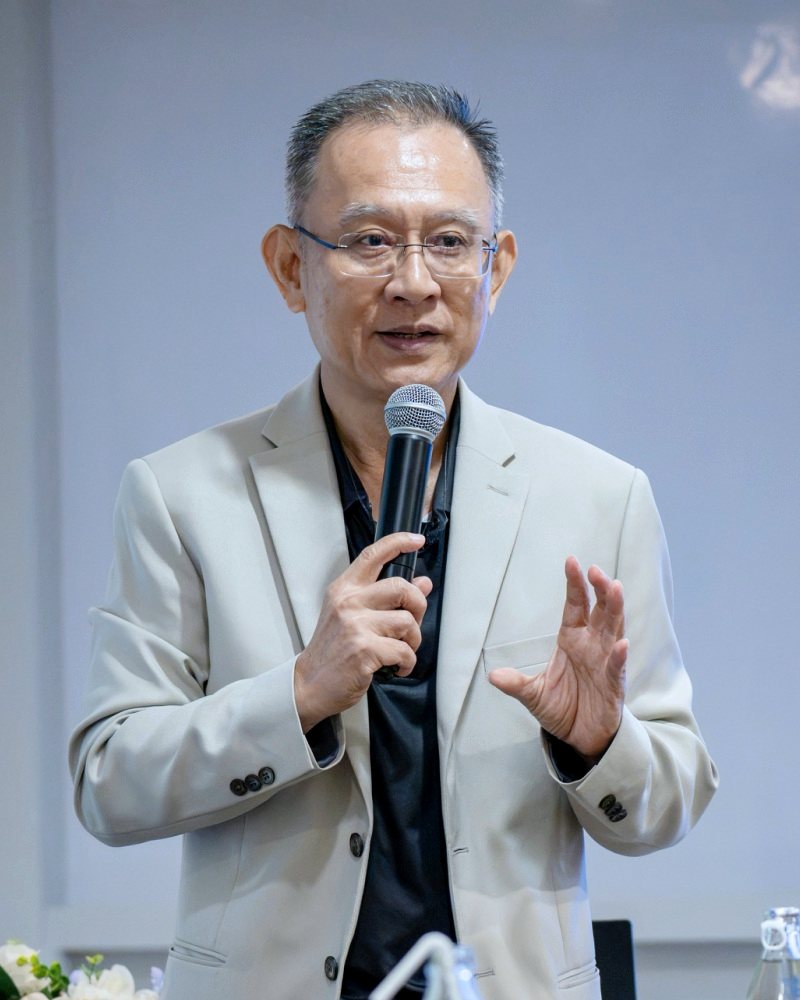 อ.ปกรณ์ วงศ์รัตนพิบูลย์ ถือไมโครโฟนบรรยายเรื่องการวัดผลลัพธ์การเรียนรู้