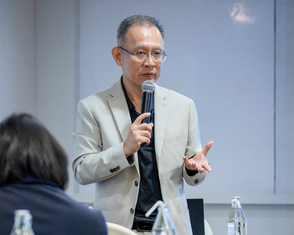 อ.ปกรณ์ วงศ์รัตนพิบูลย์ ถือไมโครโฟนบรรยาย อธิบายแนวทางการพัฒนาบุคลากรให้ผู้เข้าร่วมงาน