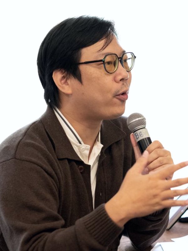 ผู้เข้าอบรมถือไมโครโฟนแลกเปลี่ยนมุมมองระหว่างการเรียนรู้ในห้องอบรม