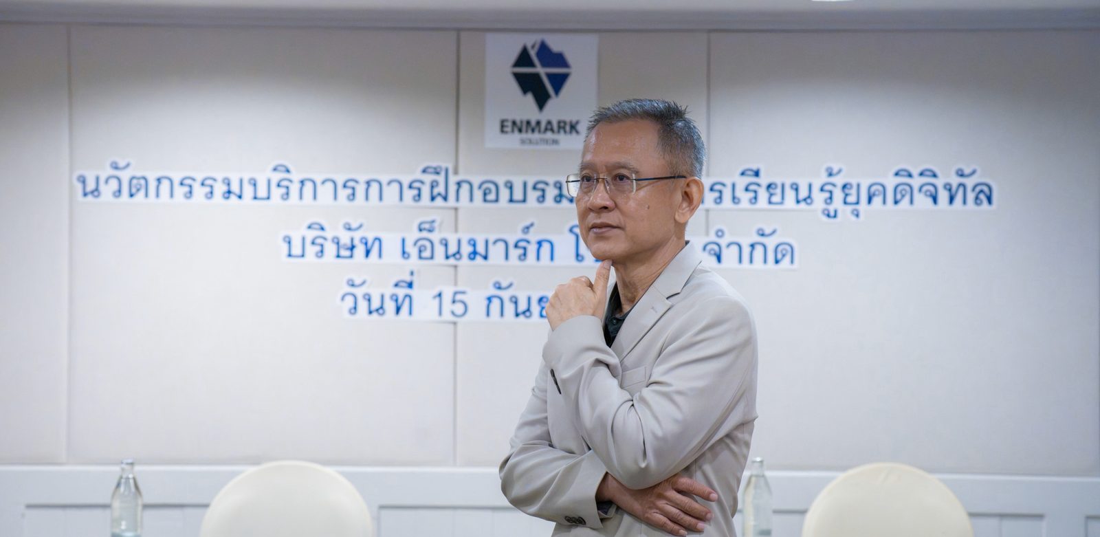 อ.ปกรณ์ วงศ์รัตนพิบูลย์ ยืนกอดอกครุ่นคิด ในงานบริการการฝึกอบรมของสถาบัน